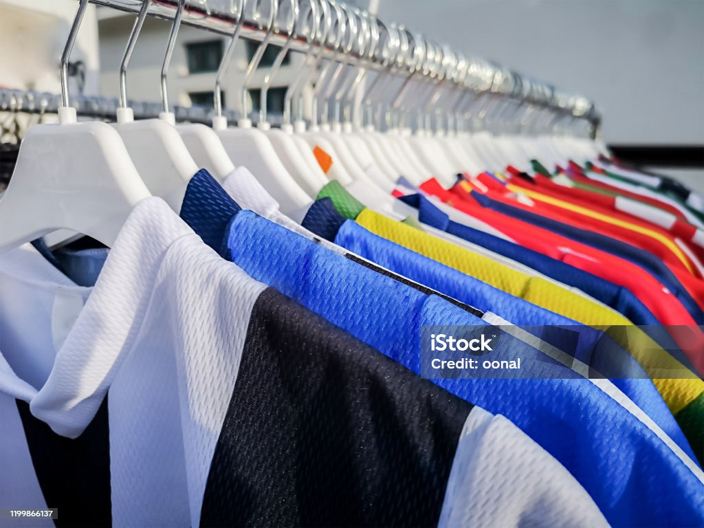 Image containing football shirts hung up on a rack